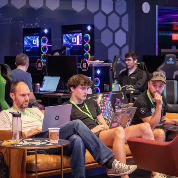 Security researchers working together on laptops at a HackerOne event