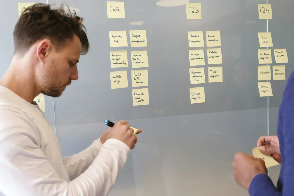 Photo: airfocus. Source: Unsplash. Stock photography. Colleagues mapping priorities with sticky notes on a planning board