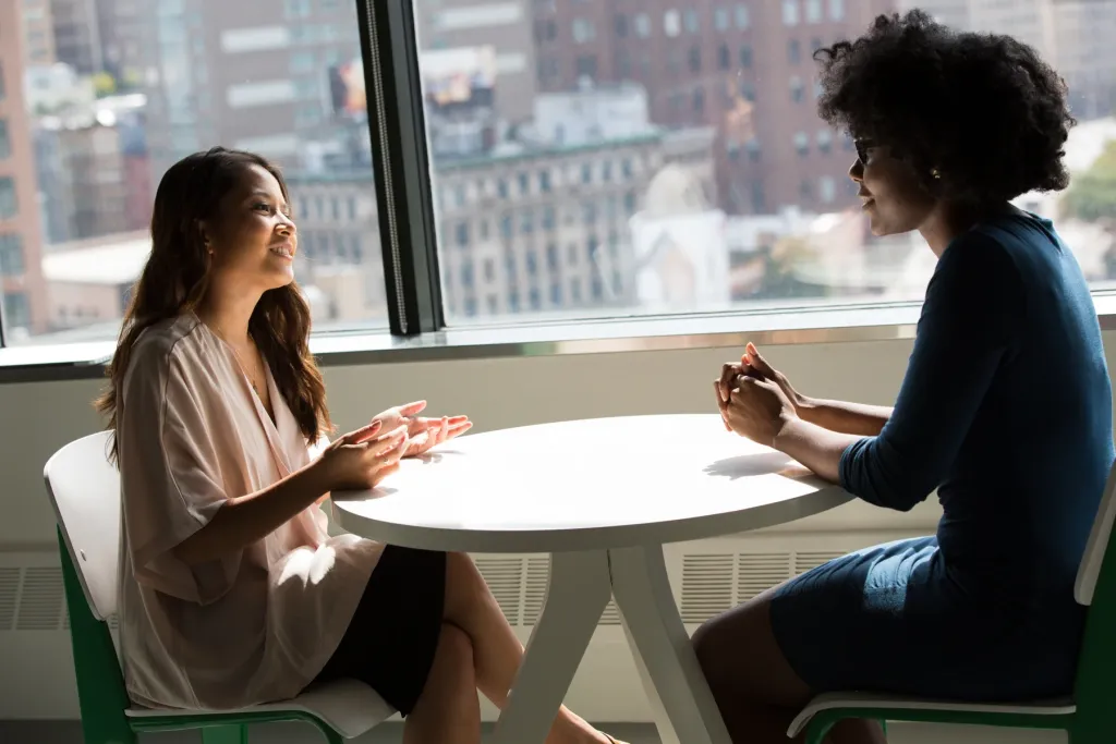 Two technology professionals talking across a table